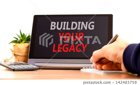 Building your legacy words symbol. Concept words Building your legacy on beautiful black tablet. Beautiful white background. Businessman hand. Business building your legacy concept. Copy space. Building your legacy words symbol. Concept words Building your legacy on beautiful black tablet. Beautiful white background. Businessman hand. Business building your legacy concept. Copy space. 142483759