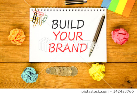 Build your brand words symbol. Concept words Build your brand on beautiful white note. Beautiful wooden background. Colored paper. Business and build your brand concept. Copy space. Build your brand words symbol. Concept words Build your brand on beautiful white note. Beautiful wooden background. Colored paper. Business and build your brand concept. Copy space. 142483760