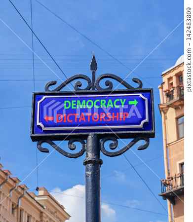 Democracy or dictatorship words symbol. Concept words Democracy Dictatorship on beautiful blue road sign. Beautiful blue sky background. Business democracy dictatorship concept. Copy space 142483809