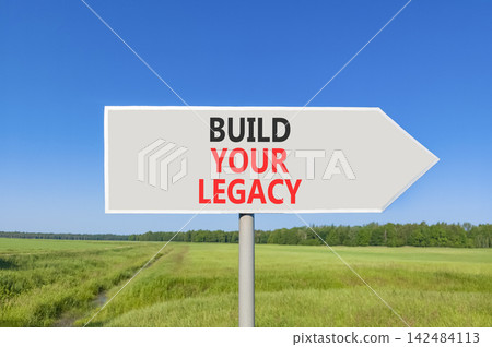 Build your legacy words symbol. Concept words Build your legacy on beautiful grey road sign. Beautiful blue sky green grass background. Business build your legacy concept. Copy space. Build your legacy words symbol. Concept words Build your legacy on beautiful grey road sign. Beautiful blue sky green grass background. Business build your legacy concept. Copy space. 142484113