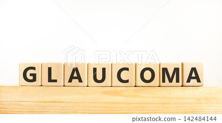 Glaucoma word symbol. Concept word Glaucoma on beautiful wooden blocks on wooden beam. Beautiful white background. Medical support help glaucoma word concept. Copy space. Glaucoma word symbol. Concept word Glaucoma on beautiful wooden blocks on wooden beam. Beautiful white background. Medical support help glaucoma word concept. Copy space. 142484144