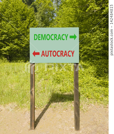 Democracy or autocracy words symbol. Concept words Democracy Autocracy on beautiful green road sign. Beautiful green forest background. Business democracy autocracy concept. Copy space Democracy or autocracy words symbol. Concept words Democracy Autocracy on beautiful green road sign. Beautiful green forest background. Business democracy autocracy concept. Copy space 142484815