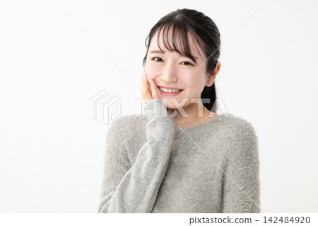 A woman who puts her hand on her cheek A woman who puts her hand on her cheek 142484920