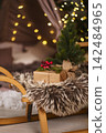Children's sledge with miniature Christmas tree and present 142484965