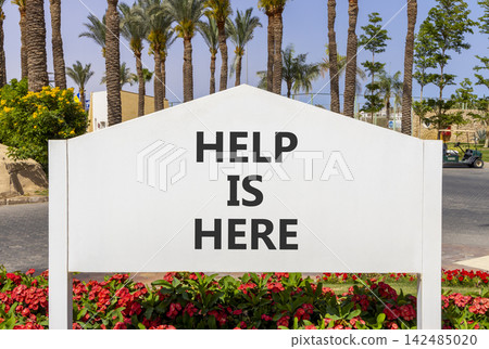 Help is here and support words symbol. Concept words Help is here on beautiful white road sign. Beautiful palm trees background. Business help is here and support concept. Copy space. Help is here and support words symbol. Concept words Help is here on beautiful white road sign. Beautiful palm trees background. Business help is here and support concept. Copy space. 142485020
