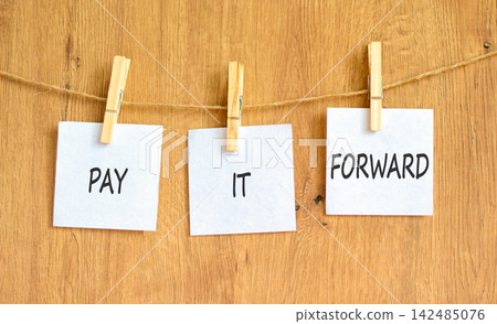 Pay it forward words symbol. Concept words Pay it forward on beautiful white papers on wooden clothespin. Beautiful wooden background. Business and pay it forward concept. Copy space. Pay it forward words symbol. Concept words Pay it forward on beautiful white papers on wooden clothespin. Beautiful wooden background. Business and pay it forward concept. Copy space. 142485076