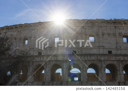 Famous Coliseum in Rome. Colosseum, or Coliseum. Sunset at huge Roman amphitheatre, Rome, Italy, Europe. Famous touristic place in the world and Europe. Beautiful blue sky background. 142485158