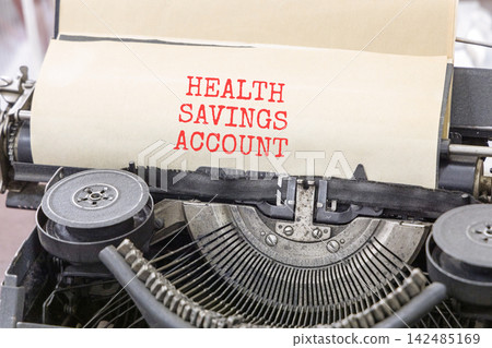 Health saving account symbol. Concept words Health saving account typed on beautiful old retro typewriter. Beautiful white background. Medical Health saving account concept. Copy space. Health saving account symbol. Concept words Health saving account typed on beautiful old retro typewriter. Beautiful white background. Medical Health saving account concept. Copy space. 142485169