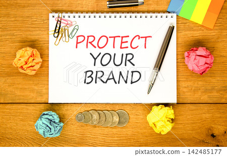 Protect your brand words symbol. Concept words Protect your brand on beautiful white note. Beautiful wooden background. Colored paper. Business and protect your brand concept. Copy space. Protect your brand words symbol. Concept words Protect your brand on beautiful white note. Beautiful wooden background. Colored paper. Business and protect your brand concept. Copy space. 142485177