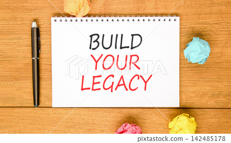 Build your legacy words symbol. Concept words Build your legacy on beautiful white note. Beautiful wooden background. Colored paper. Business build your legacy concept. Copy space. Build your legacy words symbol. Concept words Build your legacy on beautiful white note. Beautiful wooden background. Colored paper. Business build your legacy concept. Copy space. 142485178