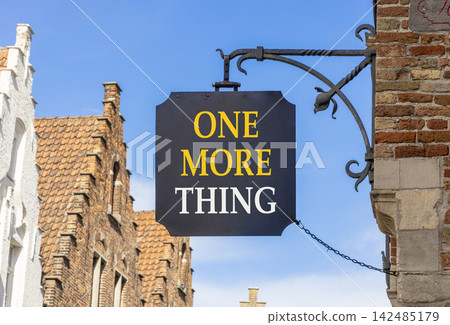 One more thing words symbol. Concept words One more thing on beautiful black road sign. Beautiful blue sky Brugge street background. Business and one more thing concept. Copy space. One more thing words symbol. Concept words One more thing on beautiful black road sign. Beautiful blue sky Brugge street background. Business and one more thing concept. Copy space. 142485179