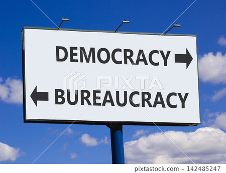 Democracy or bureaucracy words symbol. Concept words Democracy Bureaucracy on beautiful white billboard. Beautiful blue sky background. Business democracy bureaucracy concept. Copy space Democracy or bureaucracy words symbol. Concept words Democracy Bureaucracy on beautiful white billboard. Beautiful blue sky background. Business democracy bureaucracy concept. Copy space 142485247