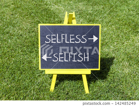 Selfless instead selfish words symbol. Concept words Selfless Selfish on beautiful yellow blackboard. Beautiful green grass background. Business medical psychology selfless selfish concept. Copy space Selfless instead selfish words symbol. Concept words Selfless Selfish on beautiful yellow blackboard. Beautiful green grass background. Business medical psychology selfless selfish concept. Copy space 142485249