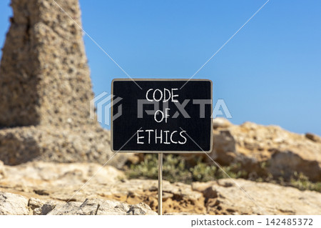 Code of ethics words symbol. Concept words Code of ethics on beautiful black blackboard. Beautiful stone and blue sky background. Business Code of ethics concept. Copy space. Code of ethics words symbol. Concept words Code of ethics on beautiful black blackboard. Beautiful stone and blue sky background. Business Code of ethics concept. Copy space. 142485372