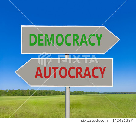 Democracy or autocracy words symbol. Concept words Democracy Autocracy on beautiful grey road sign. Beautiful blue sky background. Business democracy autocracy concept. Copy space Democracy or autocracy words symbol. Concept words Democracy Autocracy on beautiful grey road sign. Beautiful blue sky background. Business democracy autocracy concept. Copy space 142485387