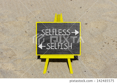 Selfless instead selfish words symbol. Concept words Selfless Selfish on beautiful yellow blackboard. Beautiful sand beach background. Business medical psychology selfless selfish concept. Copy space. Selfless instead selfish words symbol. Concept words Selfless Selfish on beautiful yellow blackboard. Beautiful sand beach background. Business medical psychology selfless selfish concept. Copy space. 142485575
