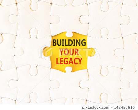 Building your legacy words symbol. Concept words Building your legacy on beautiful white puzzle. Beautiful yellow background. Business building your legacy concept. Copy space. Building your legacy words symbol. Concept words Building your legacy on beautiful white puzzle. Beautiful yellow background. Business building your legacy concept. Copy space. 142485616