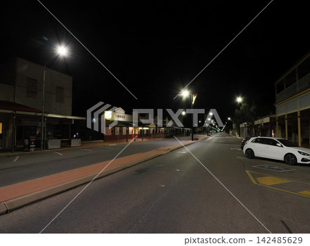 A nighttime street lined with streetlights—a Broken Hill night view, where the stillness in front of the bakery stands out. A nighttime street lined with streetlights—a Broken Hill night view, where the stillness in front of the bakery stands out. 142485629