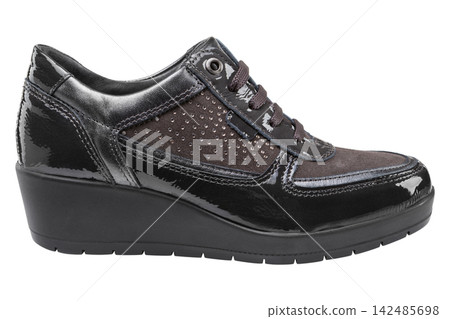 Dark brown patent leather womens wedge sneaker isolated on white background. Casual platform shoe side view Dark brown patent leather womens wedge sneaker isolated on white background. Casual platform shoe side view 142485698