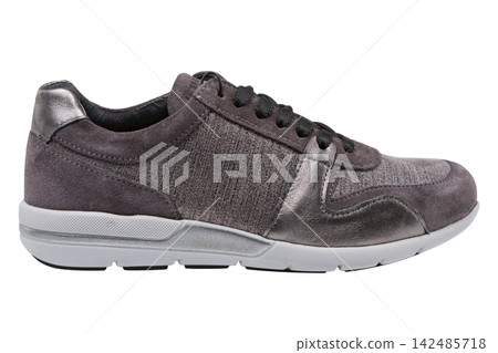 Grey suede womens sneaker with metallic trim isolated on white background. Casual running shoe side view Grey suede womens sneaker with metallic trim isolated on white background. Casual running shoe side view 142485718