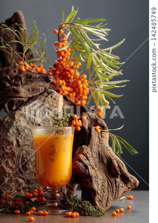 Glass mug of sea buckthorn tea with fresh berries. Glass mug of sea buckthorn tea with fresh berries. 142485749