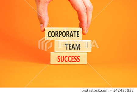 Corporate team success words symbol. Concept words Corporate team success on beautiful wooden blocks. Beautiful orange background. Businessman hand. Business corporate team success concept Copy space 142485832