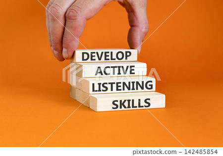 Develop active listening skills symbol. Concept words Develop active listening skills on beautiful wooden blocks. Beautiful orange background. Business active listening skills concept. Copy space. Develop active listening skills symbol. Concept words Develop active listening skills on beautiful wooden blocks. Beautiful orange background. Business active listening skills concept. Copy space. 142485854