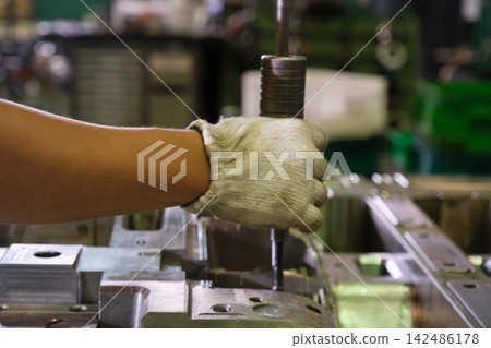 Engineers or workers are operating machinery in a factory. Engineers or workers are operating machinery in a factory. 142486178