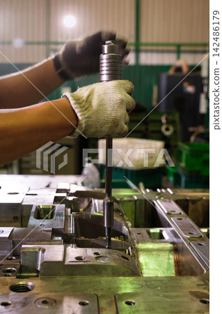 Engineers or workers are operating machinery in a factory. 142486179