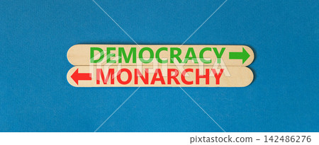 Democracy or monarchy words symbol. Concept words Democracy Monarchy on beautiful wooden sticks. Beautiful blue background. Business democracy monarchy concept. Copy space 142486276