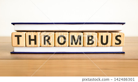 Thrombus word symbol. Concept word Thrombus on beautiful wooden blocks in beautiful book. Beautiful wooden table white background. Business medical support help thrombus word concept. Copy space. Thrombus word symbol. Concept word Thrombus on beautiful wooden blocks in beautiful book. Beautiful wooden table white background. Business medical support help thrombus word concept. Copy space. 142486301