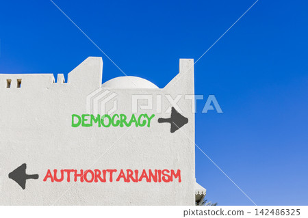 Democracy or authoritarianism symbol. Concept words Democracy Authoritarianism on beautiful white wall. Beautiful blue sky background. Business democracy authoritarianism concept. Copy space Democracy or authoritarianism symbol. Concept words Democracy Authoritarianism on beautiful white wall. Beautiful blue sky background. Business democracy authoritarianism concept. Copy space 142486325