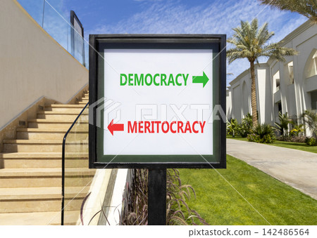 Democracy or meritocracy words symbol. Concept words Democracy Meritocracy on beautiful white road sign. Beautiful palm trees background. Business democracy meritocracy concept. Copy space 142486564