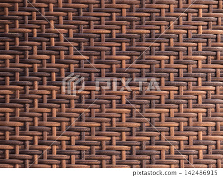 Synthetic rattan material creating a seamless interwoven pattern with contrasting shades of brown and tan, offering a durable and decorative surface texture Synthetic rattan material creating a seamless interwoven pattern with contrasting shades of brown and tan, offering a durable and decorative surface texture 142486915