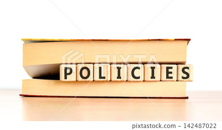 Policies word symbol. Concept word Policies on beautiful wooden blocks in beautiful book. Beautiful wooden table white background. Business support help policies word concept. Copy space. Policies word symbol. Concept word Policies on beautiful wooden blocks in beautiful book. Beautiful wooden table white background. Business support help policies word concept. Copy space. 142487022