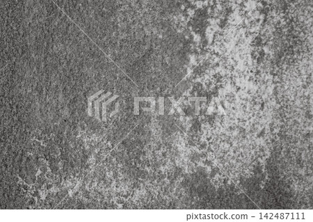 Grungy concrete wall with white efflorescence streaks and dark shadows, weathered, textured surface ideal as rugged and aged background 142487111