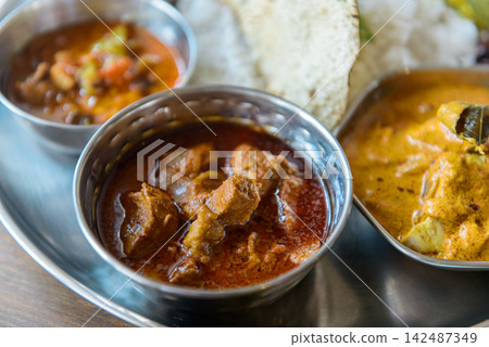 Indian curry and basmati rice served on a stainless steel plate: South Indian thali (meals). Indian curry and basmati rice served on a stainless steel plate: South Indian thali (meals). 142487349