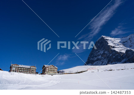 The breathtaking panoramic view of Kleine Scheidegg, with its clear blue sky and towering snow-capped mountains. The breathtaking panoramic view of Kleine Scheidegg, with its clear blue sky and towering snow-capped mountains. 142487353
