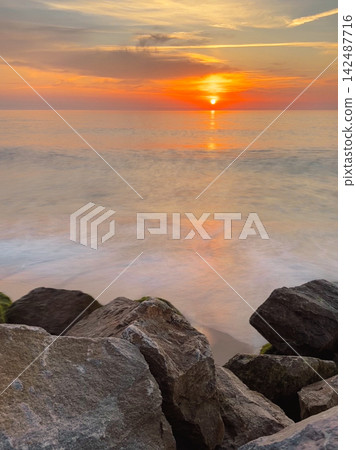 Golden Ocean Sunset over Coastal Rocks in Furadouro Golden Ocean Sunset over Coastal Rocks in Furadouro 142487716