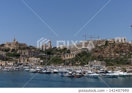 Modern resort buildings and yachts in Mgarr harbor marina, Gozo island, Malta, June 19, 2026. Modern resort buildings and yachts in Mgarr harbor marina, Gozo island, Malta, June 19, 2026. 142487999