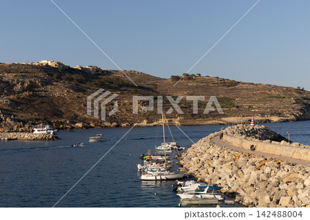 Scenic view of Mgarr harbor with boats moored at stone breakwater pier in Gozo, Malta, June 19, 2026 Scenic view of Mgarr harbor with boats moored at stone breakwater pier in Gozo, Malta, June 19, 2026 142488004
