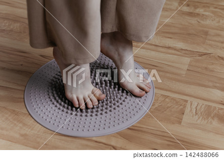 Sole stimulation. girl stands on massage mat. Massage and healthy lifestyle. Treatment of flat feet and hallux valgus. Sole stimulation. girl stands on massage mat. Massage and healthy lifestyle. Treatment of flat feet and hallux valgus. 142488066