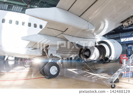 Commercial Aircraft Engine Undergoing Maintenance in an Aviation Hangar. Airplane under maintenance. Checking mechanical systems for flight operations Commercial Aircraft Engine Undergoing Maintenance in an Aviation Hangar. Airplane under maintenance. Checking mechanical systems for flight operations 142488129