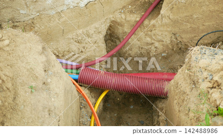 Fiber optic internet infrastructure cables copper engineering networks conduits laying installed underground excavated soil trench construction excavated digging routing pathway, protective placed Fiber optic internet infrastructure cables copper engineering networks conduits laying installed underground excavated soil trench construction excavated digging routing pathway, protective placed 142488986