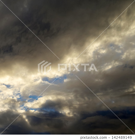 cumulus gray clouds with blue sky opening and golden sunset light cumulus gray clouds with blue sky opening and golden sunset light 142489149