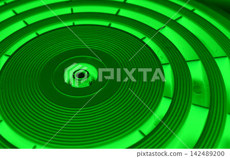 Geometrical concentric circles of varying thickness on a circular panel with intensive green illumination Geometrical concentric circles of varying thickness on a circular panel with intensive green illumination 142489200