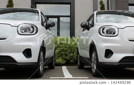 Front Parts Of Small Vehicles On A Parking Near Office Entrance Front Parts Of Small Vehicles On A Parking Near Office Entrance 142489296