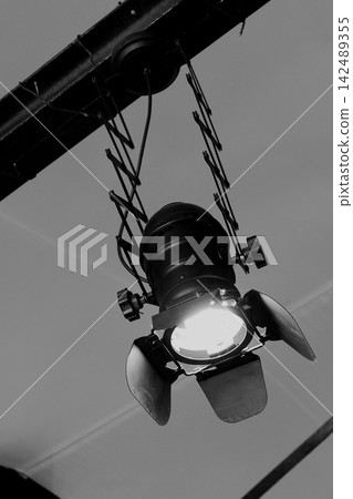 Black spotlight on the scissor ceiling fixture black and white image. Stage lighting rail system 142489355