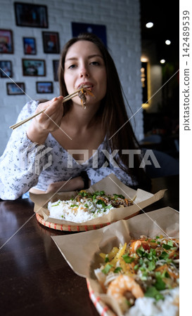Close-up of Caucasian woman eating pan-Asian cuisine Close-up of Caucasian woman eating pan-Asian cuisine 142489539