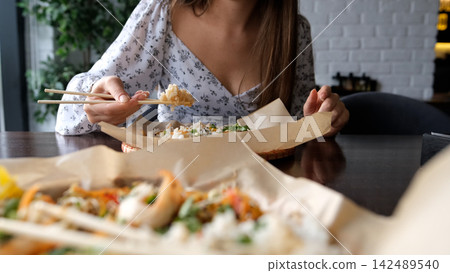 Close-up of Caucasian woman eating pan-Asian cuisine Close-up of Caucasian woman eating pan-Asian cuisine 142489540